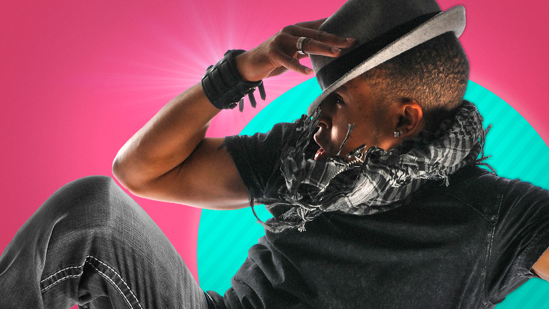 A closeup of a young African-American male dancer posing with his hand on his fedora